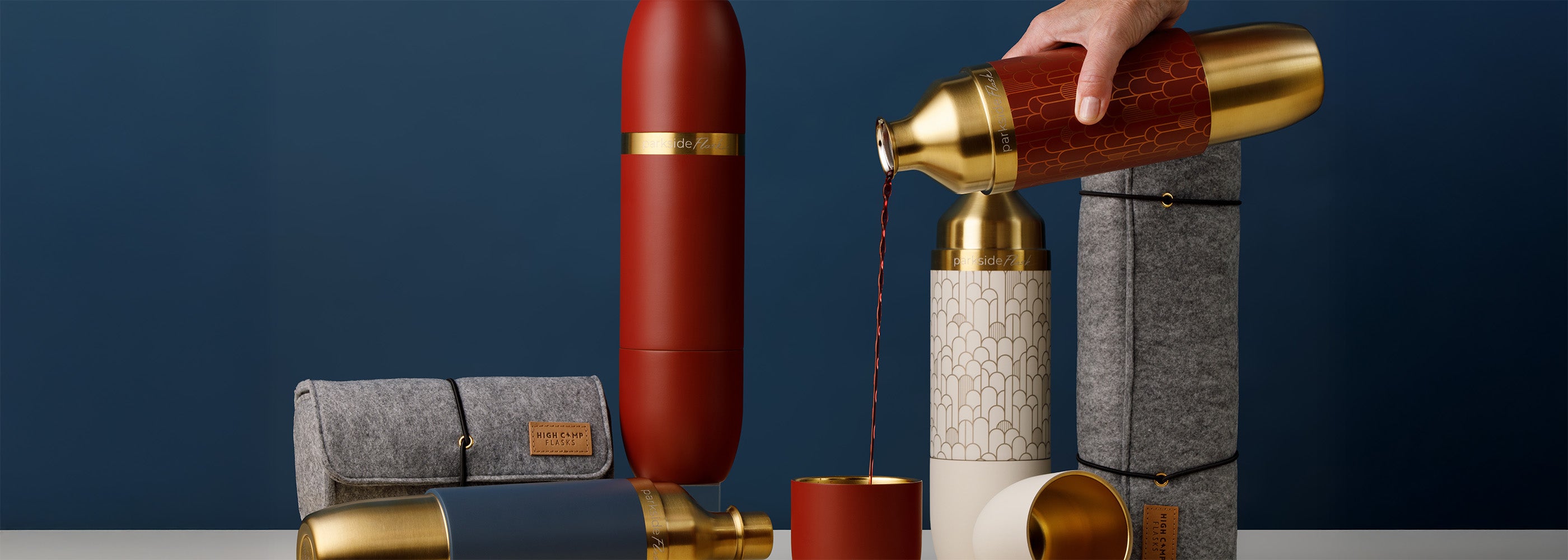 Decorative items including a red cylindrical object, gold accents, and a gray pouch on a dark blue background.